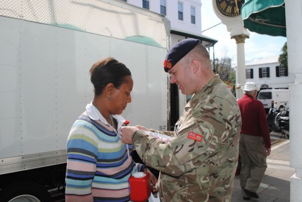Captain Clifford Powell, ADC to the Governor, pins a poppy on a buyer