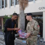 Regiment L Corporal Chris Matvey sells a poppy to a man on Parliament Street