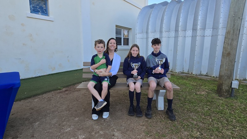 Reid Kempe Daughter Zoe Kempe Gibson and Grandson Archer Gibson with Fastest Girl Evelyn Fahy and Fastest Boy Jarred Jones on bench Bermuda March302026